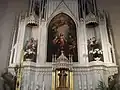 Maître-autel néo-gothique avec tableau représentant la sainte Famille, une statue de saint Joseph et une statue de saint Antoine de Padoue tous deux tenant l'Enfant-Jésus