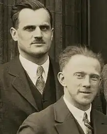 Photo sépia. Deux hommes en veston souriants légèrement font face à l'appareil-photo.