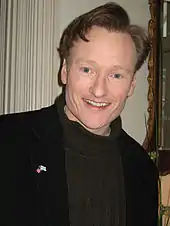 Photographie d’une homme souriant regardant la caméra.