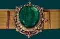 La ceinture du couronnement : cette ceinture a été tissée en fils d'or, elle mesure 119 cm de long. L'émeraude formant une partie de la boucle pèse 175 carats et est entourée de nombreux petits diamants. L'histoire de cette ceinture n'est pas connue, hormis le fait qu'elle remonterait au moins au XVIIe&nbsp;siècle. Les deux chahs Pahlavi l'ont portée pour leur couronnement.
