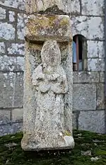 Croix du cimetière : sainte Brigitte portant un renard dans ses bras
