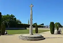 Vue de la croix avec l'église en arrière-plan.