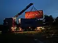 Déchargement d'un conteneur maritime 20 pieds d'occasion par bras de grue.
