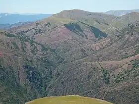 Vue du dôme de Barrot avec sa masse de 900 m d'épaisseur de pélites rouges du Permien entamées ici par le ruisseau de Raton, affluent de rive ouest du Cians.