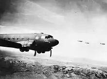 Quatre avions à double hélice survolent une chaîne de montagnes