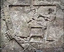 Un devin et son assistant préparent un animal en vue d'un sacrifice divinatoire. Détail d'un bas-relief de Nimroud, IXe&nbsp;siècle&nbsp;av. J.-C. British Museum.