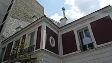 Bâtiment au murs rouge foncé et blanc.