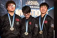 Trois joueurs en survêtements, médaille autour du cou.