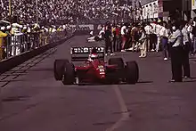 Photo de la Dallara 191 rouge, vue de face, de Pirro, dans la voie des stands du Grand Prix des États-Unis