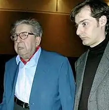Photographie en couleurs d'un homme âgé accompagné par un plus jeune.