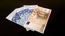 Poignée de cinq billets, quatre de 20 euros et un de 50 euros.