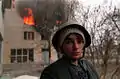 Sur cette photographie, l'innocence impuissante le cède au tragique, souligné par la maison en flammes.