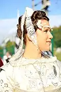 Coiffe et costume blanc du XXe&nbsp;siècle.
