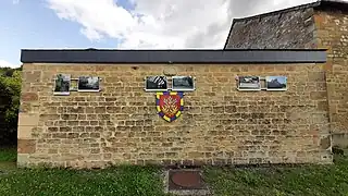 Façade du lavoir avec le blason de la commune.