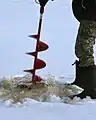 Une perceuse à glace en action.
