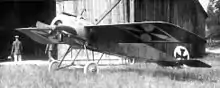 Photo noir et blanc d'un avion monoplan devant un hangar