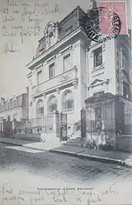 Façade principale vue latéralement depuis la rue, au tournant du XXe siècle.