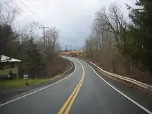Direction ouest sur l'ancien NY 319, à l'est du hameau de Preston. On peut y apercevoir une route s'apprêtant à faire un virage à l'ouest. Cette route prend place à l'ancien lieu où se situait NY 319.