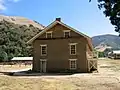 Bâtiment des casernes restaurées à l'extrémité orientale. Le mess/cuisine non reconstruit est indiqué par une clôture sur la gauche.