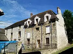 Le logis de l'ancienne ferme, sur la Grande-Rue, au village. La tente dans la cour protège du mobilier céramique sorti de fouille.