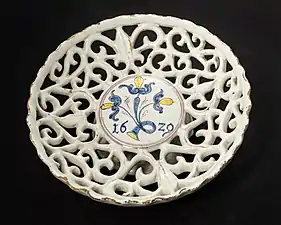 Coupe à pied (environ 7 cm de haut, 20 cm de diamètre), en faïence ajourée à glaçure au dioxyde d'étain en forme de vigne, produite en 1629 dans l'ouest de la Slovaquie/Moravie (peut-être à Sobotište), l'une des plus anciennes œuvres connues des Haban&nbsp;(de).
