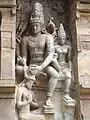 Avec Parvati à sa gauche, Shiva rend hommage à Candesha (en) en lui nouant un turban autour de la tête. Face Nord, accès à l'antichambre, mur du déambulatoire