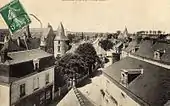 Vue d'un bourg prise d'un point haut, rue et maisons en contrebas, église en arrière plan.