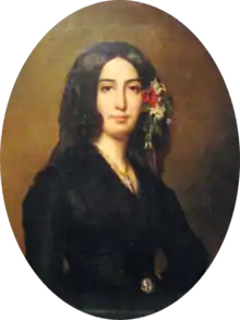 Portrait ovale d'une femme en buste vêtue de noir, les yeux noirs, des cheveux bruns encadrant le visage et mêlés de fleurs
