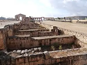L'hippodrome, vu du nord : piste et substructions des gradins. Arc d'Hadrien reconstruit  au fond  à gauche.