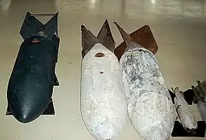 Bombes allemandes de Seconde Guerre mondiale : à gauche, un bombe explosive SC 250 et à droite quatre bombes d’exercice en béton (de 250&nbsp;kg et 50&nbsp;kg)