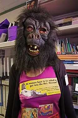Guerrilla Girl posant avec un tshirt reprenant la sérigraphie Do Women Have To Be Naked To Get Into the Met Museum.