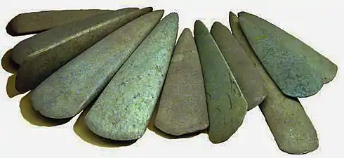 Haches polies découvertes dans le dépôt de Bernon (Arzon, Morbihan).Ces pièces de grande dimension (15 à 28 cm) datent du Ve millénaire av. J.-C. Certaines sont en fibrolite locale, d'autres sont en roches vertes alpines et ont probablement été obtenues par échange.