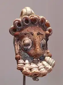 Tête d'homme barbu en pâte de verre au musée du Louvre (IVe – IIIe siècles av. J.-C.).