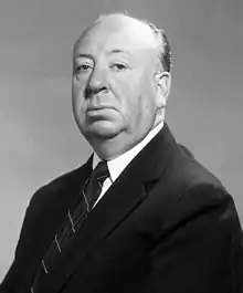 Photo publicitaire de studio d'Alfred Hitchcock en costume.