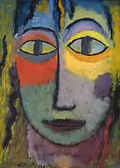 Visage multicolore, les yeux aux pupilles verticales, le nez droit, avec un air