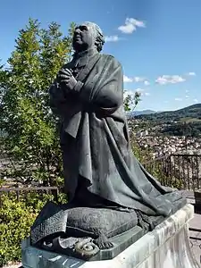 Statue de l'évêque, Auguste de Morlhon, au pied de la statue de la Vierge.