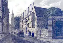 Un bâtiment de trois étages avec des fenêtres disposées régulièrement, des cheminées et une entrée à la décoration élaborée, attenant à un bâtiment avec une grande fenêtre gothique. Dans la rue des gens déambulent ainsi que des chevaux et des carrosses. La flèche d'une église est visible en arrière plan.