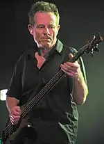 photo d'un homme en polo noir jouant de la basse.