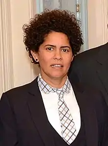 Photo couleur d'une femme aux cheveux frisés avec une cravate.