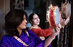 Des femmes observent la lune à travers des tamis pendant Karwa Chauth.
