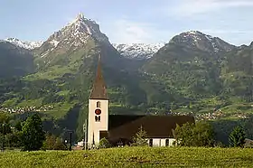L'église Saint-Gall, avec en arrière plan le Mürtschenstock&nbsp;(en) à gauche, et le Nüenchamm à droite.