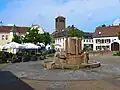 Place du village avec fontaine et église St. Joseph et St. Wendelin