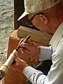 Artisan fabriquant une poupée kokeshi.
