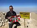 Alpiniste posant devant la plaque.