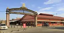 Photographie d'un portique en brique et en bois sur lequel il est écrit « Jesselton Point - Selamat Datang ».