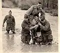 À gauche Jean Pierre Brûlard MPLF[pas&nbsp;clair], Alain Copel, Roger Stella, Jean Pierre Morvan, portant le lieutenant François Raoul sur leurs épaules dans l'oued Bellah en crue.