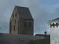 Clocher en bâtière du XIe&nbsp;siècle vu par-dessus les toits du village
