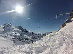 Photographie de la Tyrolienne d'Orelle qui passe au-dessus du vallon du Bouchet enneigé.