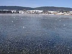 Vue de la commune avec le lac gelé en premier plan.