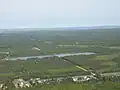 Les bassins du parc industriel. Le parc éolien de Lamèque est visible au loin.